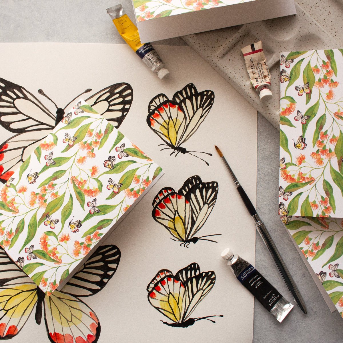 Butterfly designs and painting supplies on a table