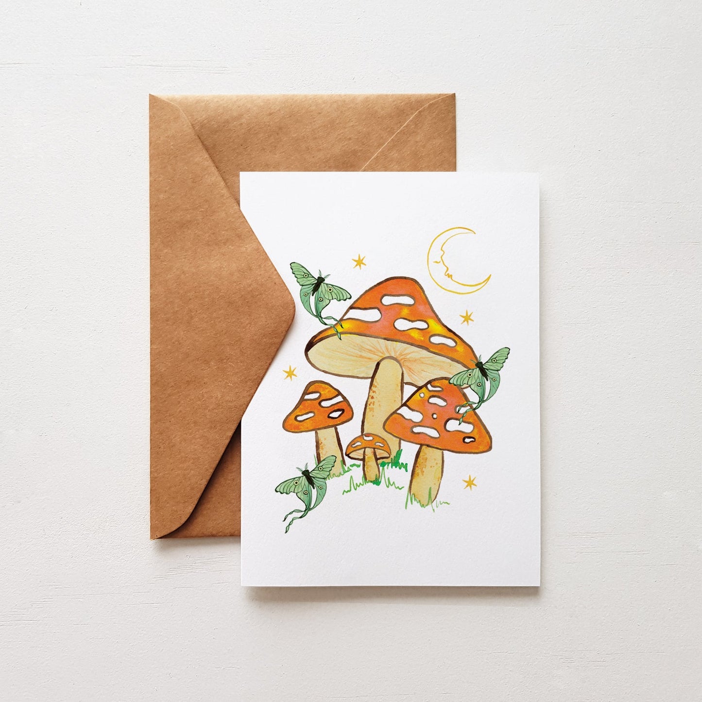 Greeting card with mushroom design and brown envelope on white background