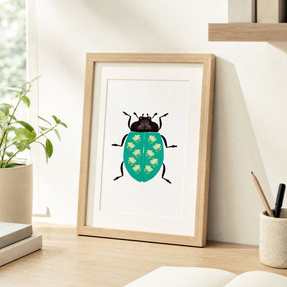 Framed artwork of a beetle on a desk with a plant and stationery