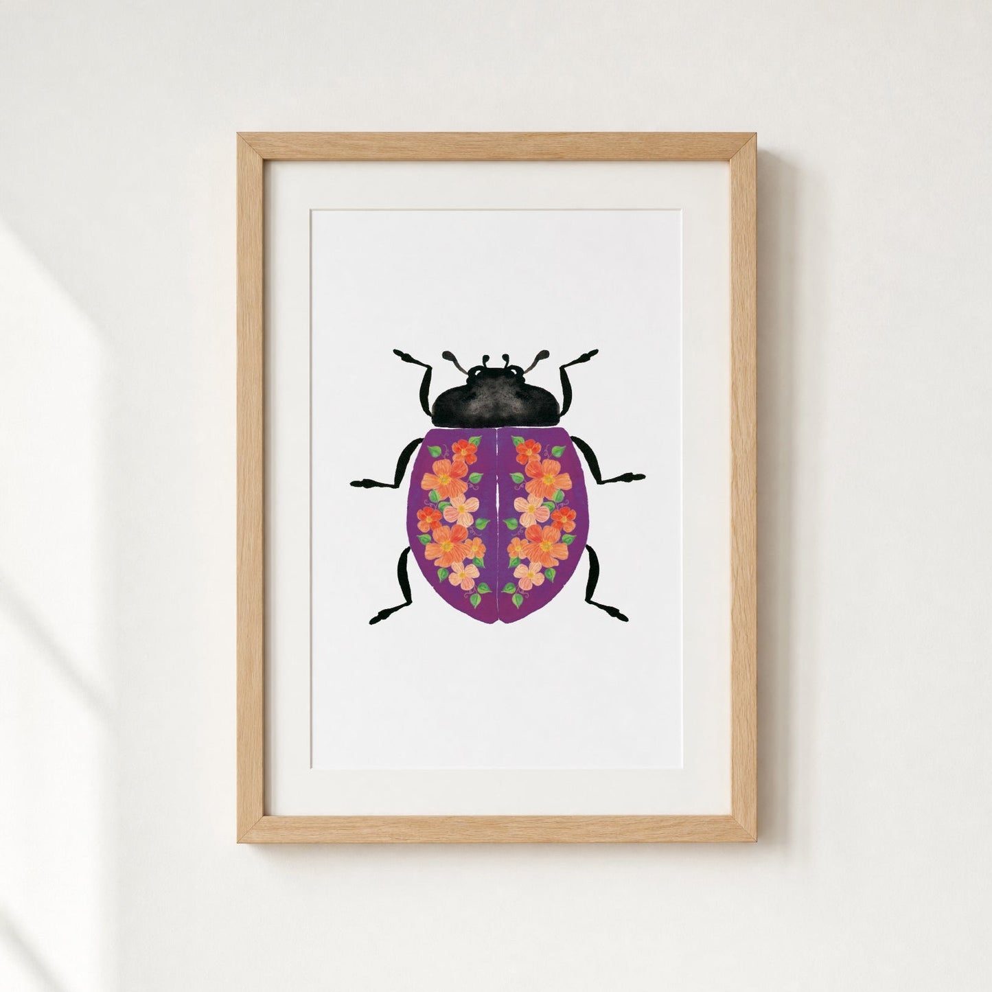 Framed artwork of a purple beetle with flowers on it's shell