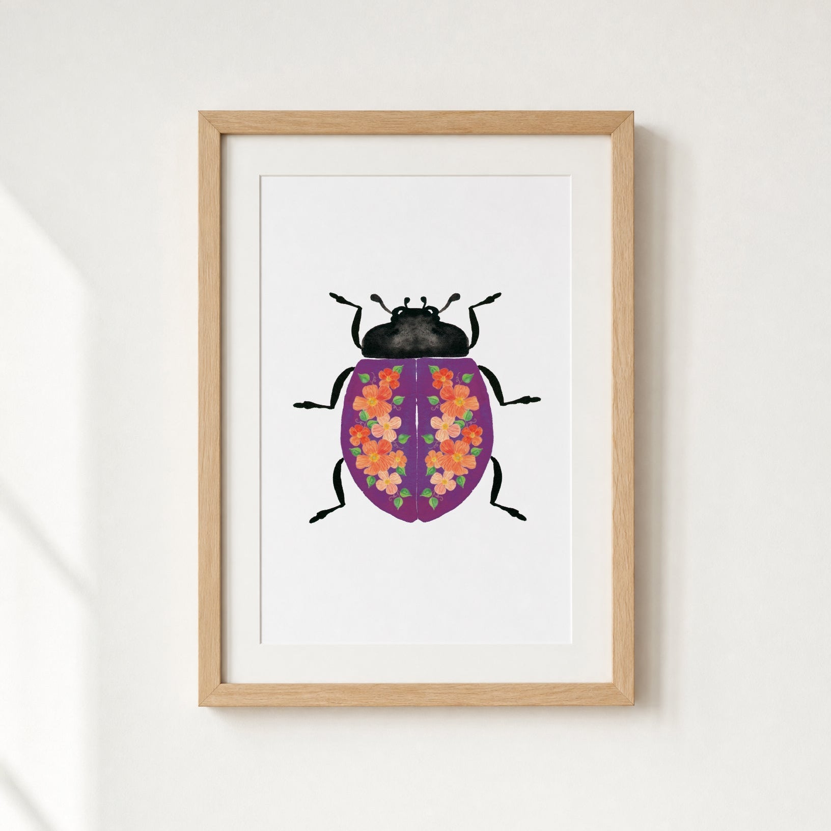 Framed artwork of a purple beetle with flowers on it's shell