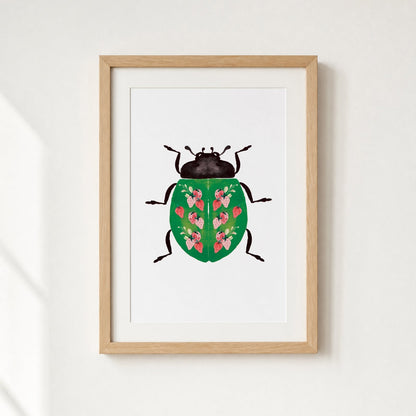 Framed artwork of a beetle with strawberries design on a white wall