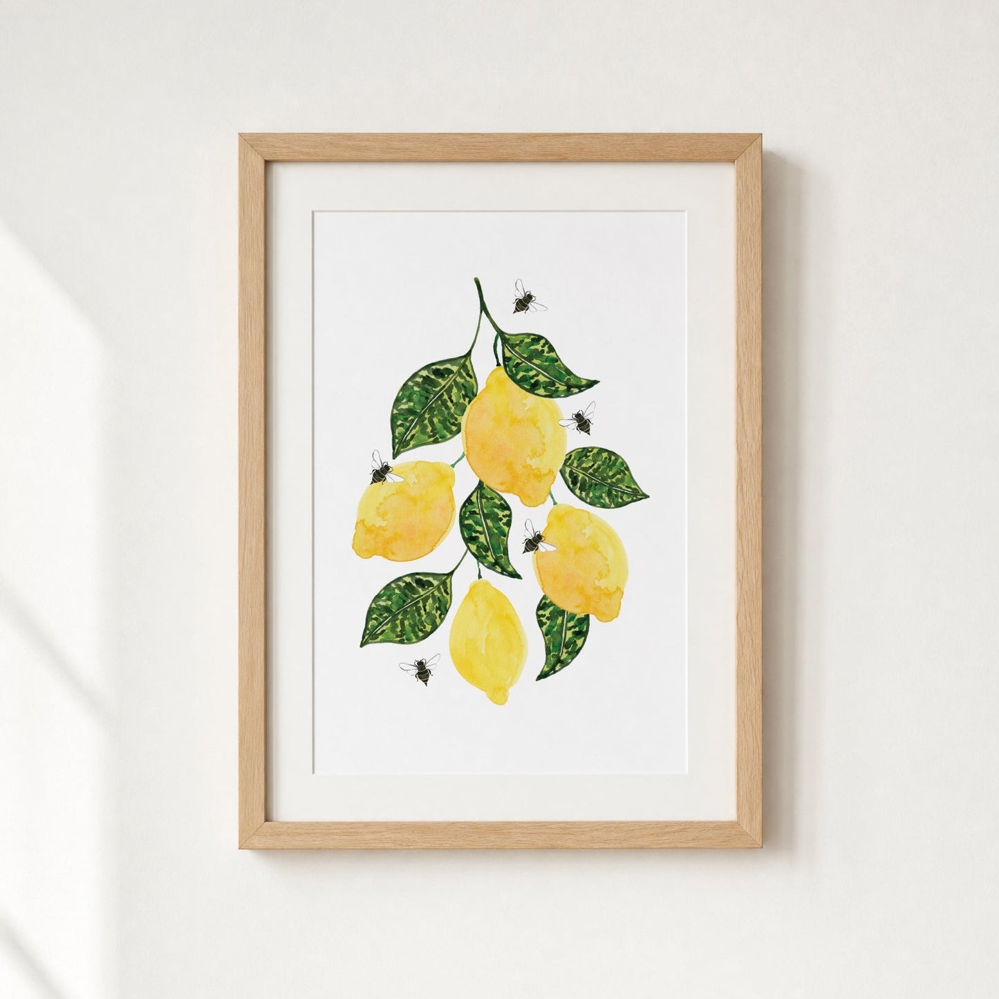 Framed artwork of lemons and leaves on a white background
