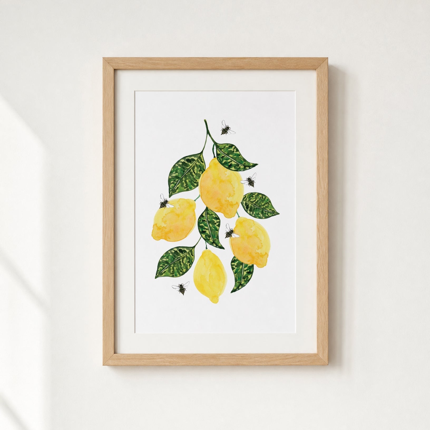 Framed artwork of lemons and leaves on a white background