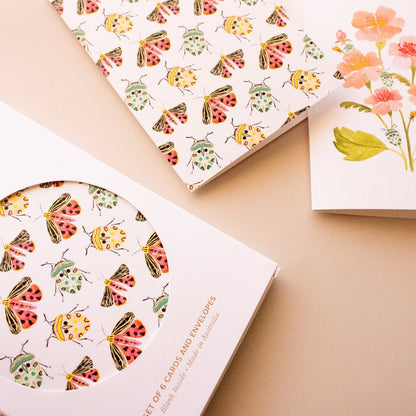 Botanical greeting card set with teal beetles, colourful moths and pink flowers