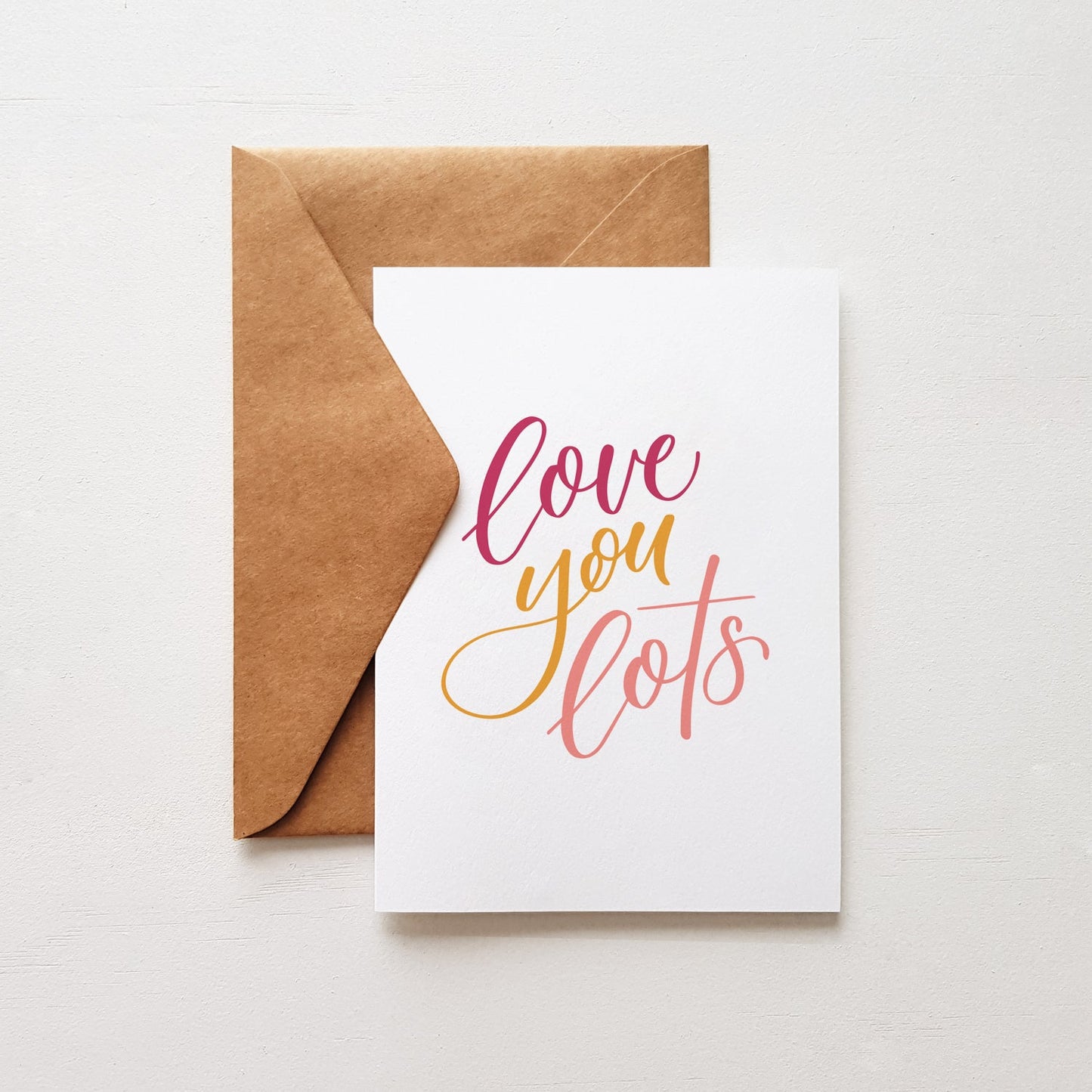 'love you lots' greeting card with a brown envelope on a white background