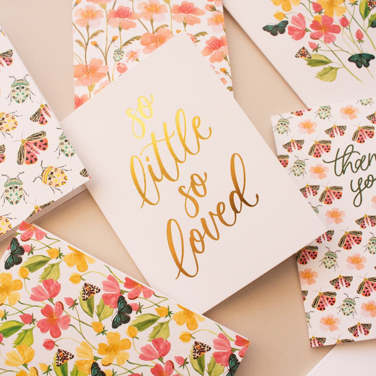 Collection of floral and text cards on a beige surface