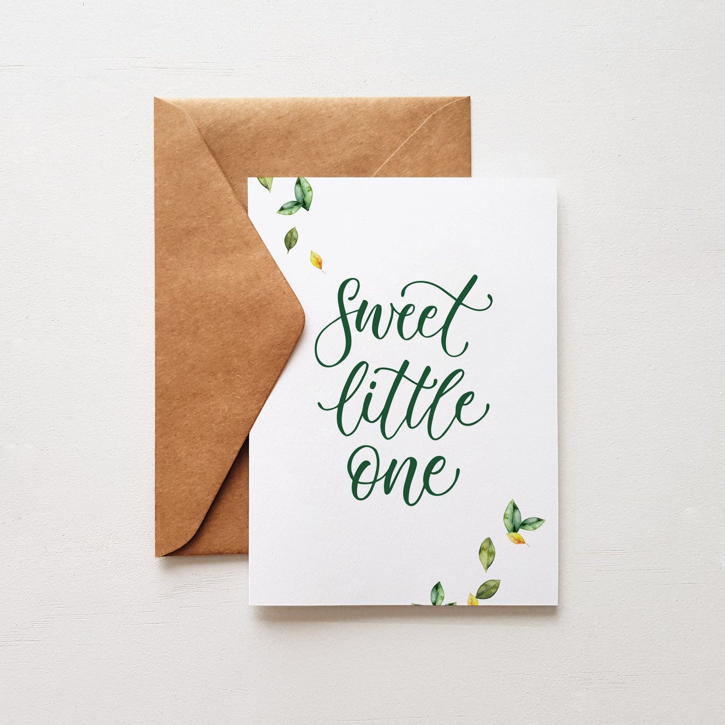 botanical baby greeting card with leaves and green lettering 'Sweet little one' on a brown envelope
