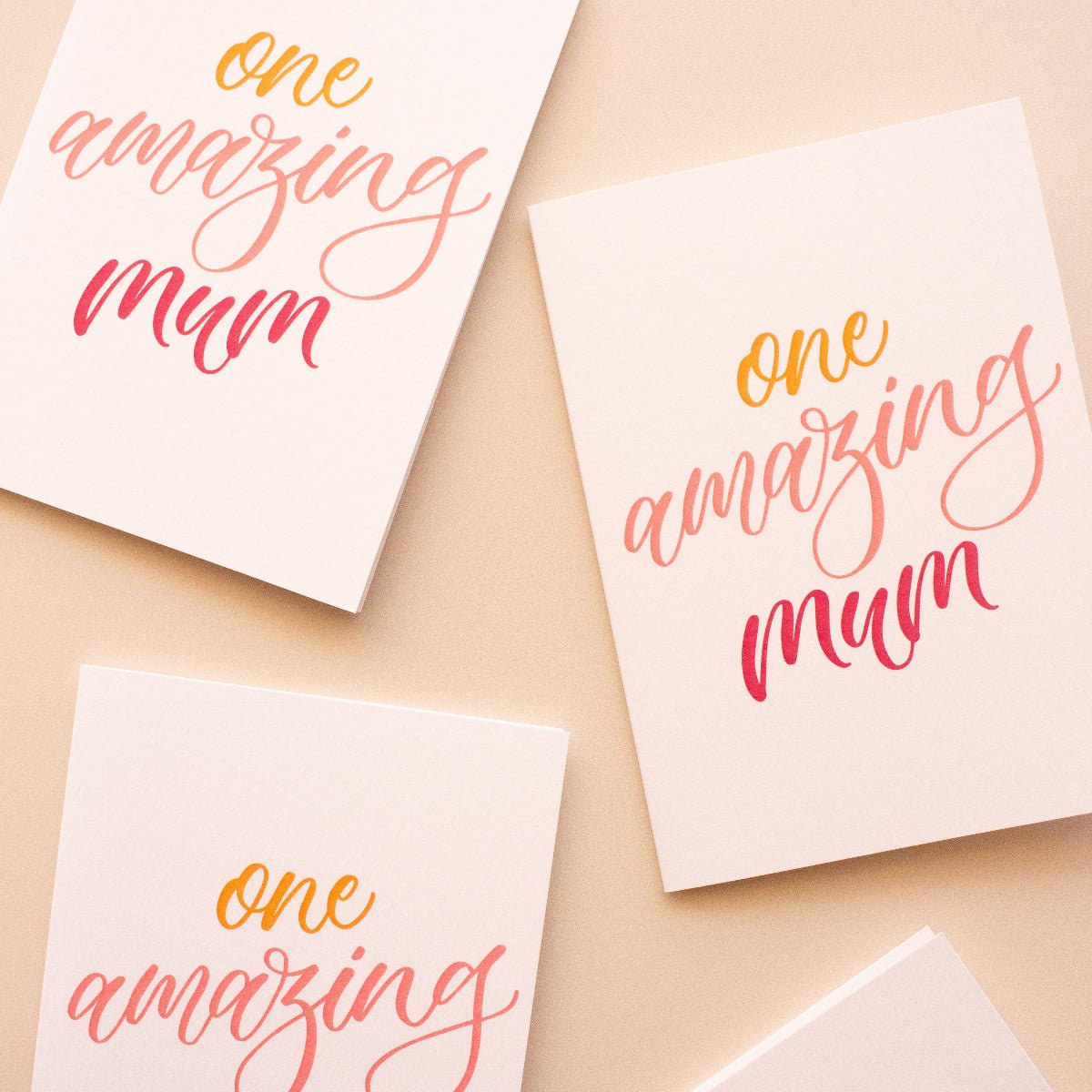 Four greeting cards with 'one amazing mum' text on a beige background
