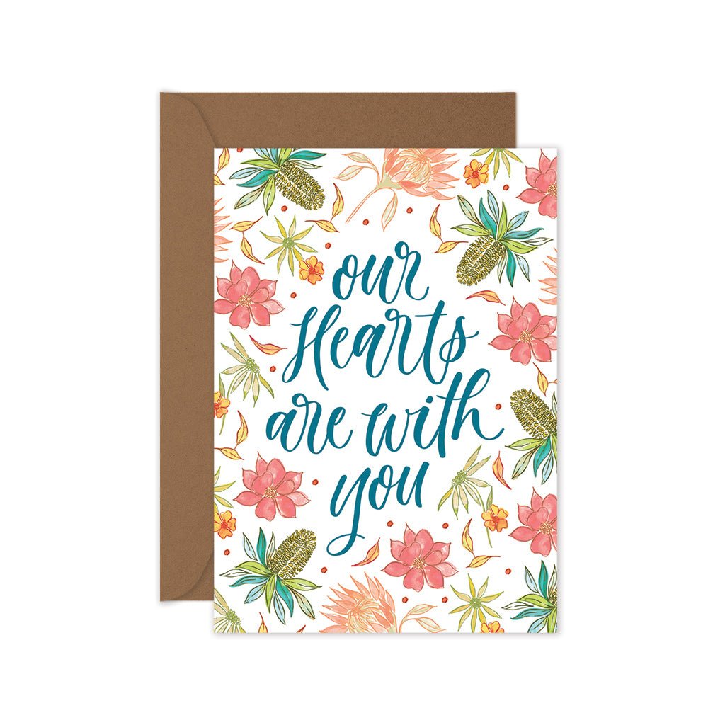 A greeting card with flowers and the text 'our hearts are with you' on the front, and brown kraft envelope.