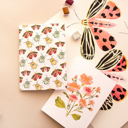 Pink flower greeting card featuring teal beetle illustration and botanical art