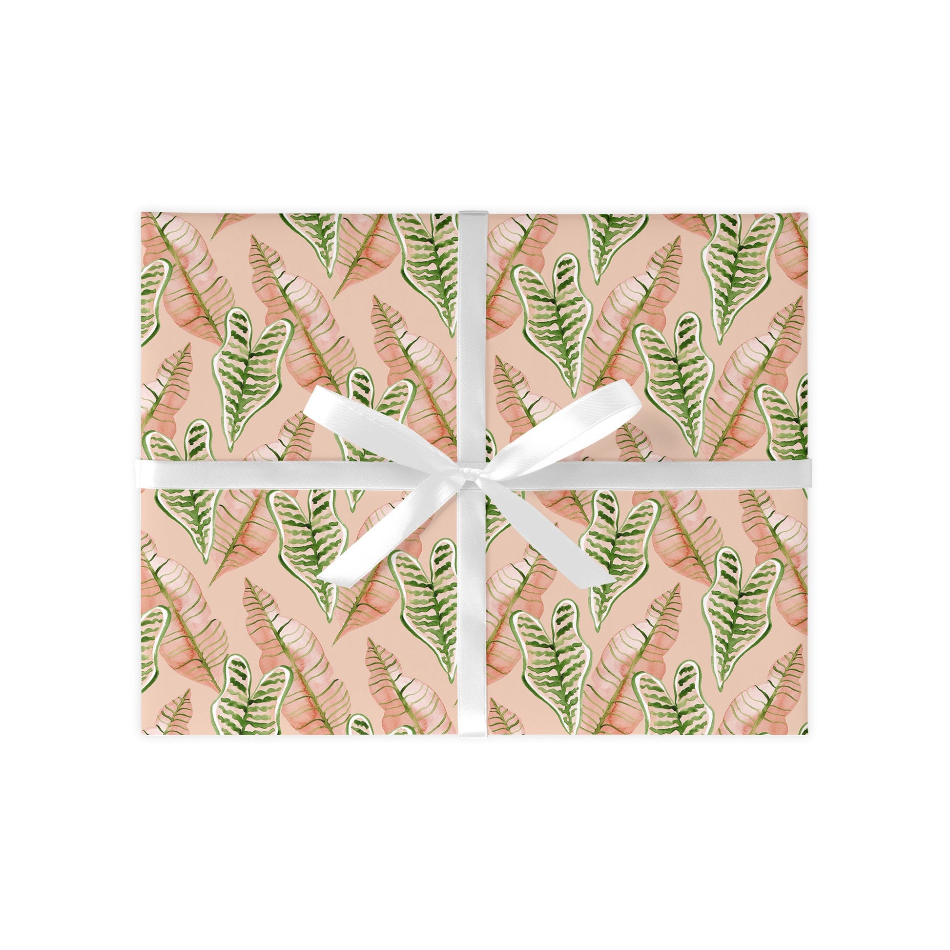 Gift box with a leaf pattern and white ribbon on a white background