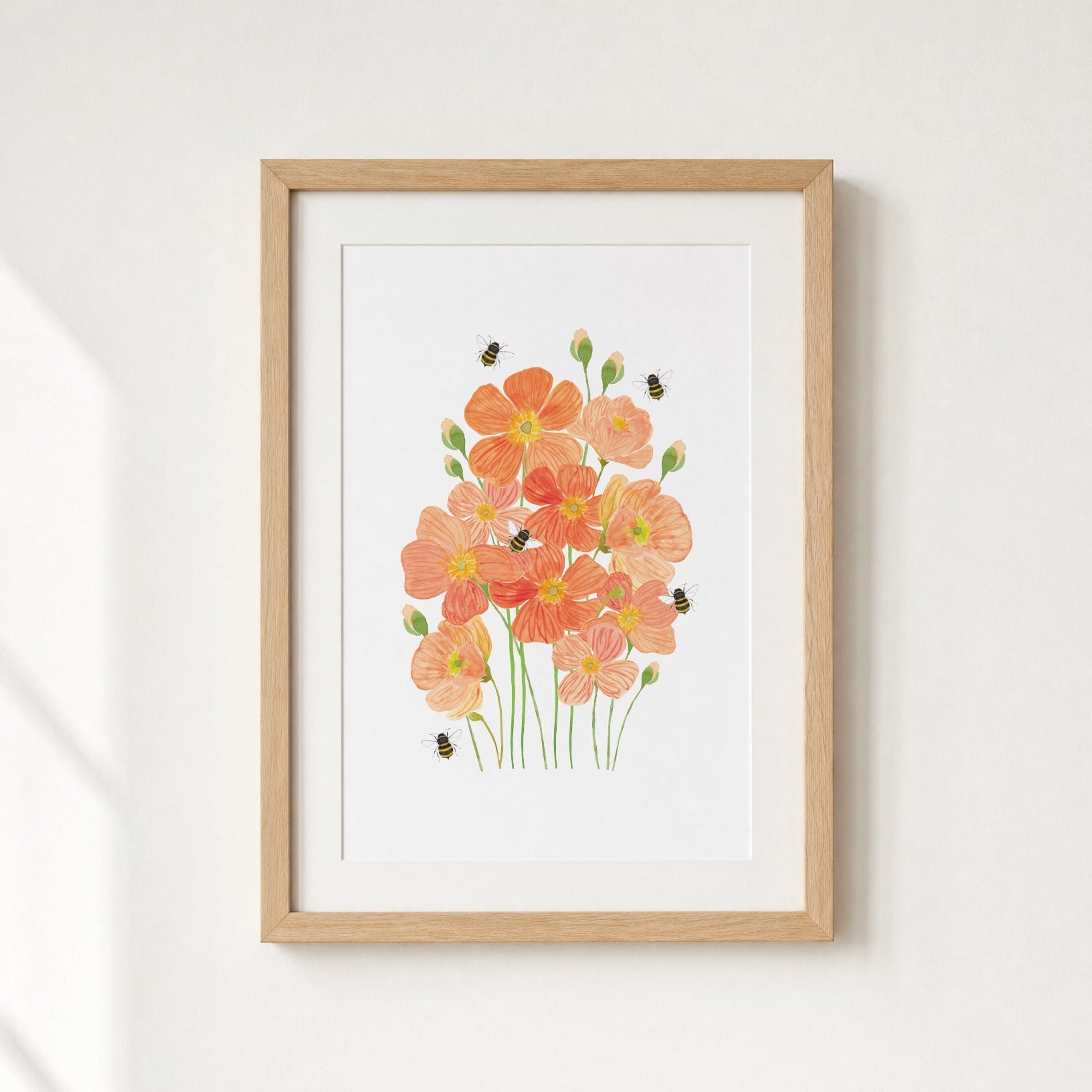 Framed artwork of orange flowers on a white wall