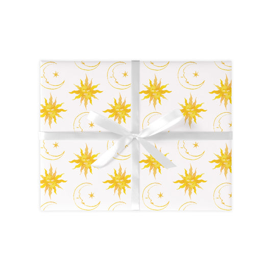 Wrapped gift on a white background with yellow suns and moons repeat pattern. Present tied together with a white ribbon.