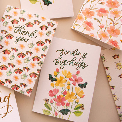 Collection of various greeting cards with floral designs and text on a beige background