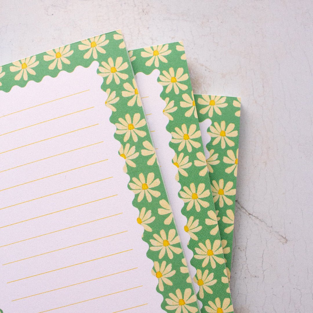 Notepad with floral design on a light grey surface