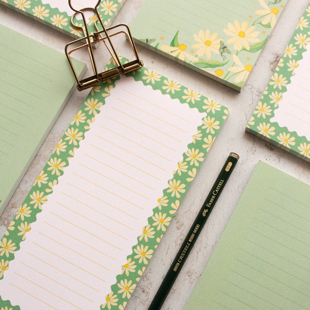 Charming teal DL notepads featuring a daisy design with lined pages for writing and journaling.