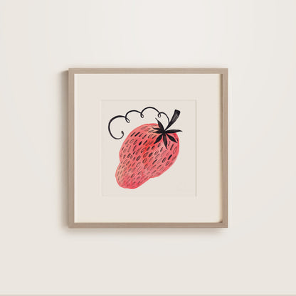 Framed artwork of a strawberry on a white wall