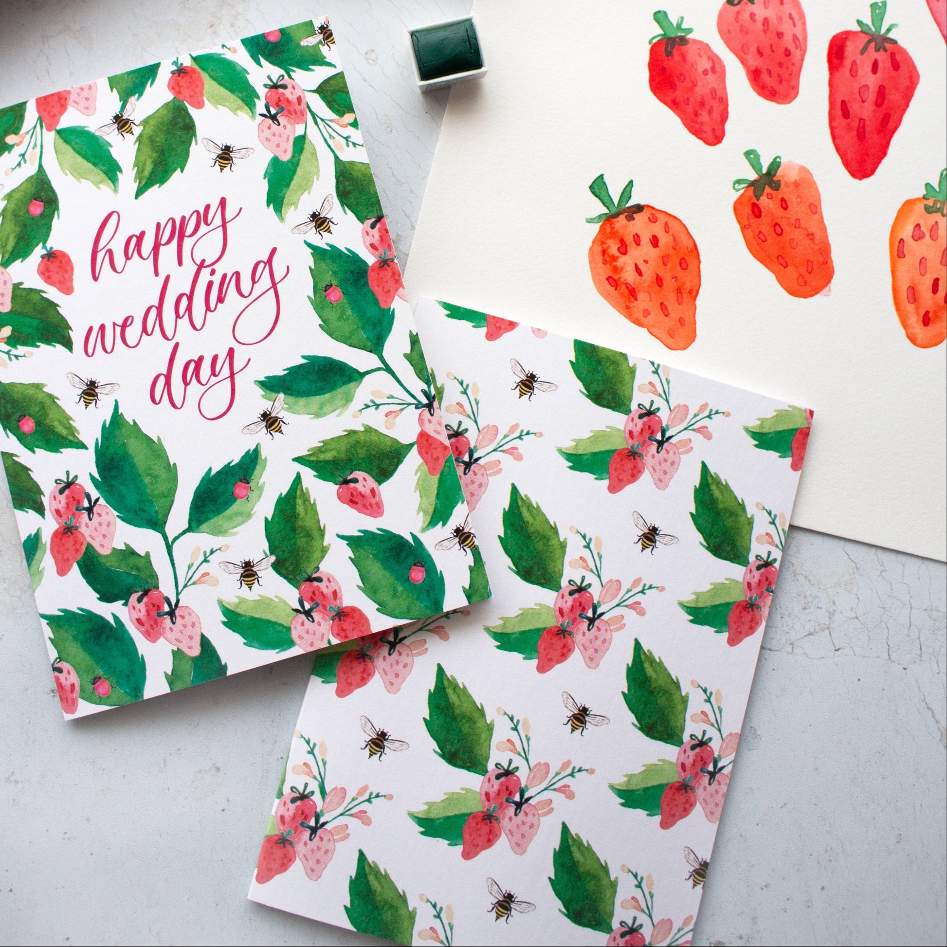 Floral and strawberry-themed stationery items on a light surface