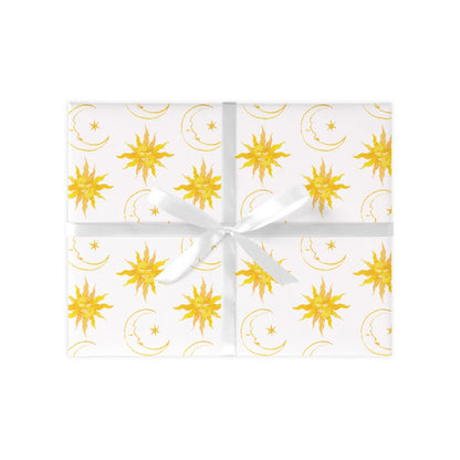 Wrapped gift on a white background with yellow suns and moons repeat pattern. Present tied together with a white ribbon.