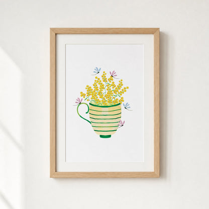 Framed artwork of a teacup with yellow flowers on a white wall