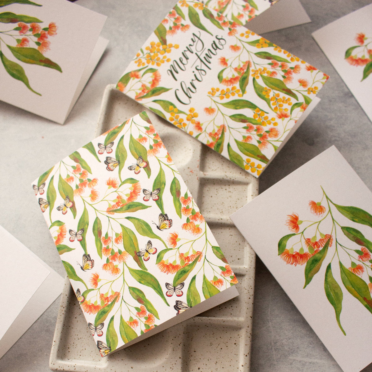 Floral and Christmas-themed greeting cards on a textured surface