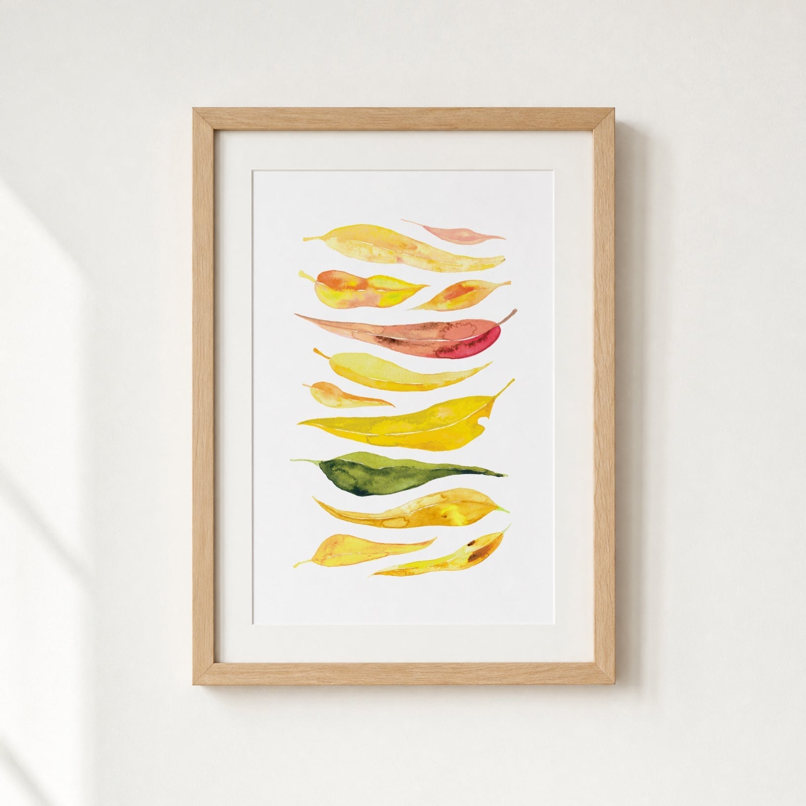 Framed artwork of colorful leaves on a white background