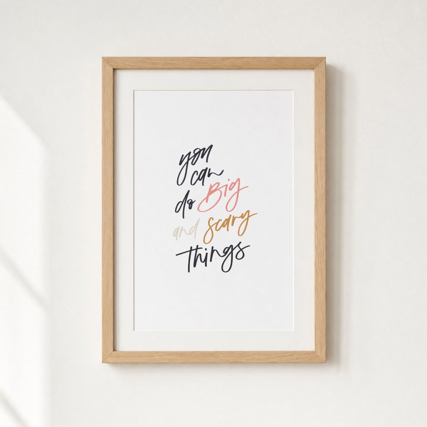 Framed print with motivational quote on a white wall