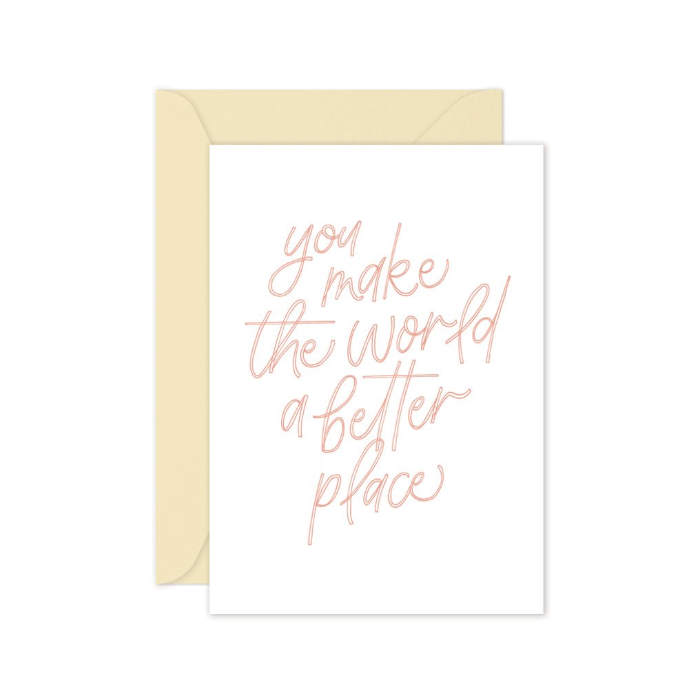 Greeting card with pink text saying 'you make the world a better place' with a cream envelope on a white background