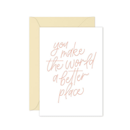 Greeting card with pink text saying 'you make the world a better place' with a cream envelope on a white background