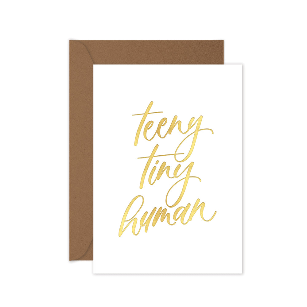 Gender neutral baby greeting card with gold lettering 'teeny tiny human' with brown envelope
