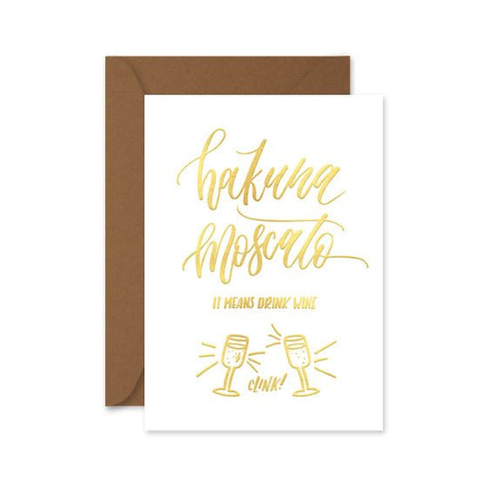 gold foiled card with the words 'hakuna moscato, it meants drink wine' and a brown envelope