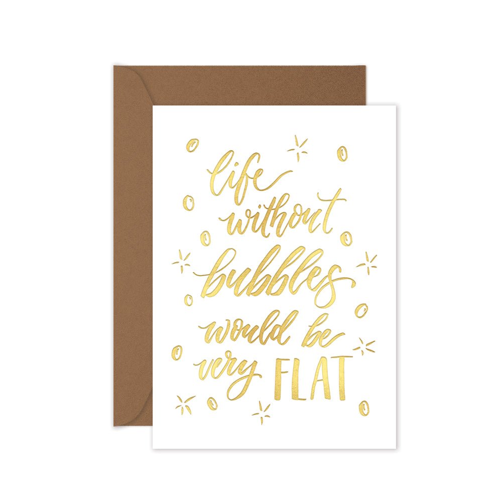 a gold foiled greeting card with the script 'life without bubbles would be very flat' with a brown kraft envelope