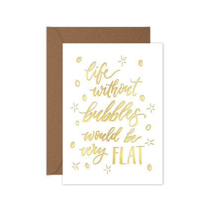 a gold foiled greeting card with the script 'life without bubbles would be very flat' with a brown kraft envelope