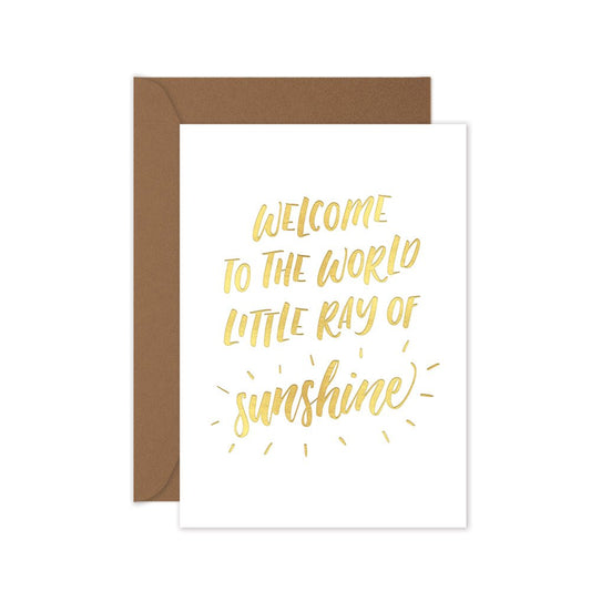 Gold foiled greeting card with the words 'welcome to the world little ray of sunshine' with a brown envelope