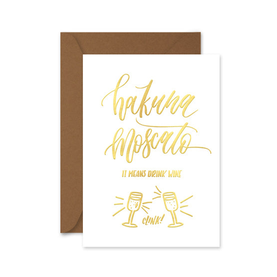 gold foiled card with the words 'hakuna moscato, it meants drink wine' and a brown envelope